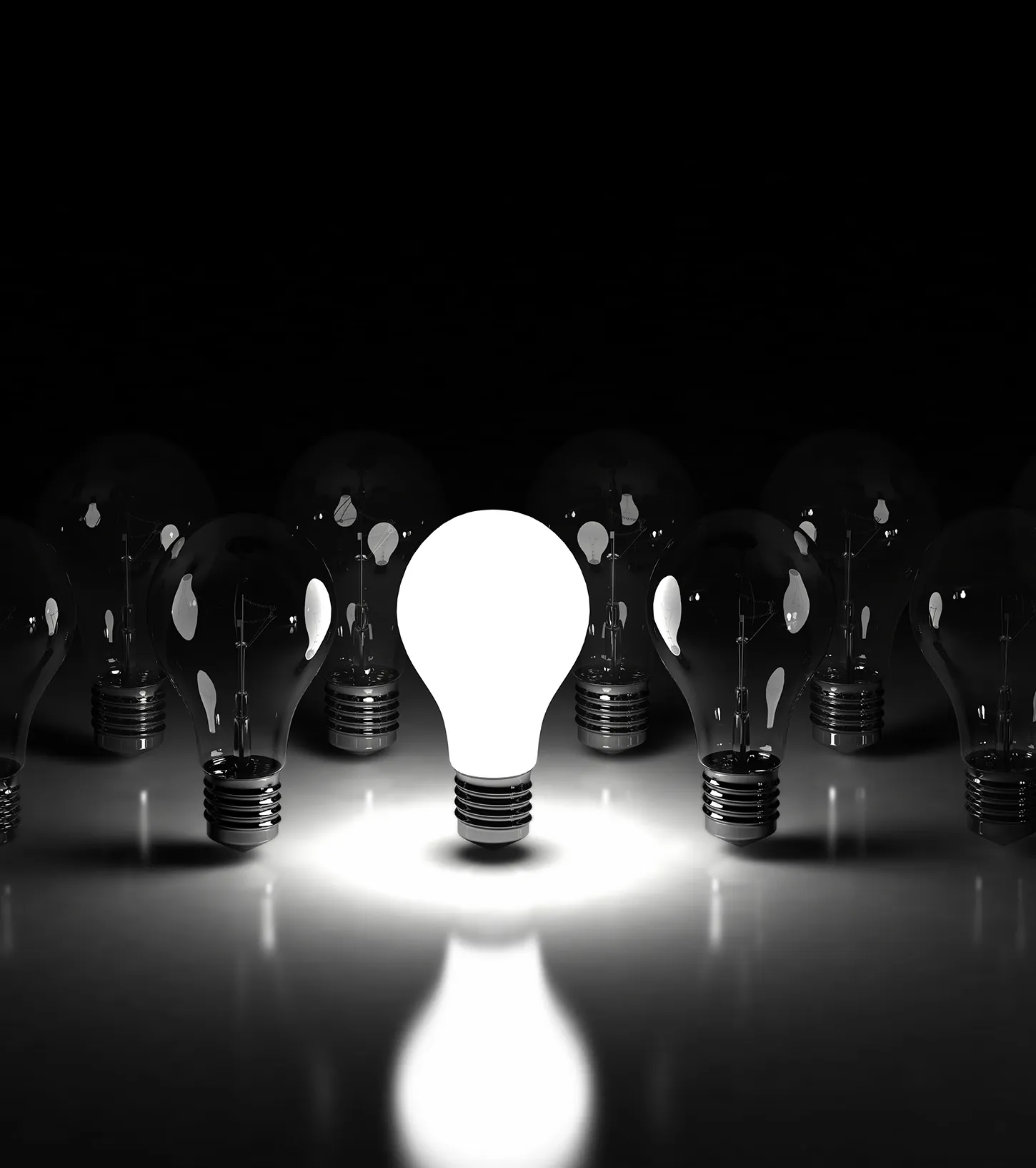 Lightbulb glowing among unlit bulbs symbolizing unique social media ideas